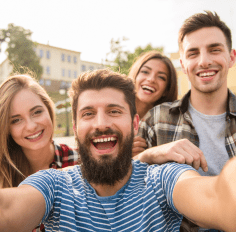 Four people take a selfie on the street